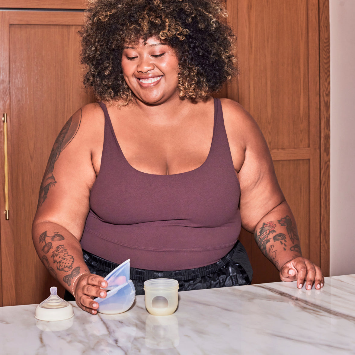Woman pouring breastmilk from a Muu pump into a bottle.